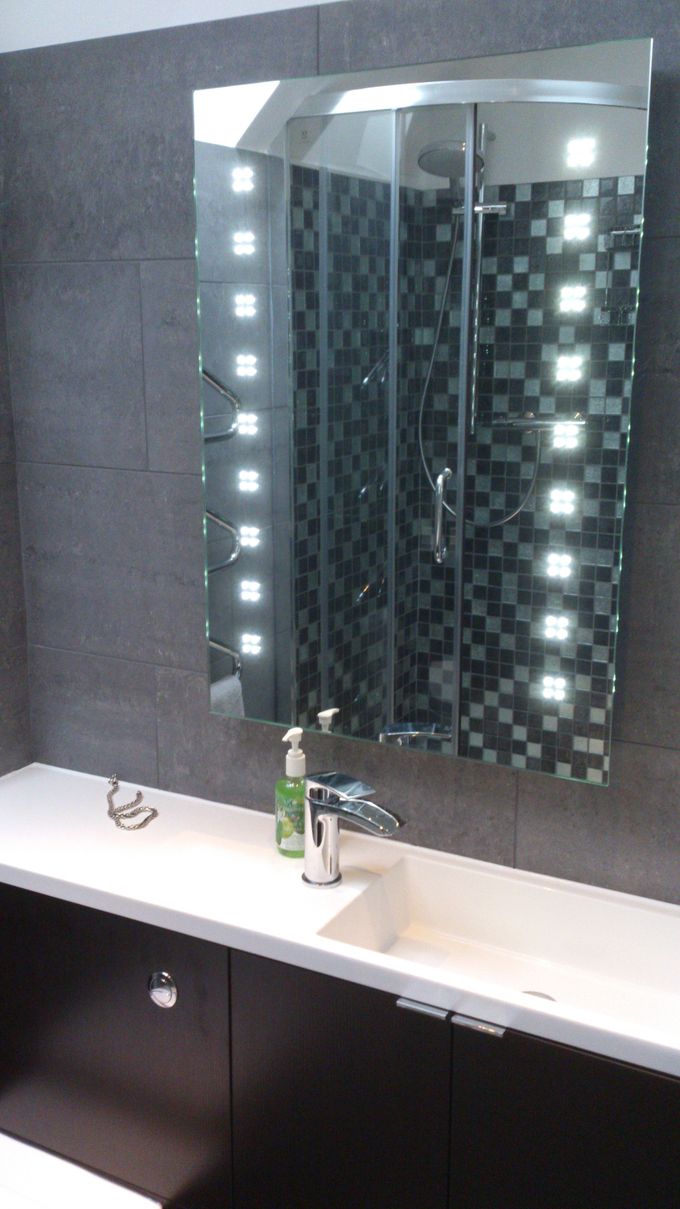 Piper-Power transformed an unloved ensuite into a hotel-chic ensuite with shower, toilet and as you see here in the picture - compact basin and mono tap on dark wood unit, with illuminated mirror above showing the new shower! The owner now loves their ensuite.